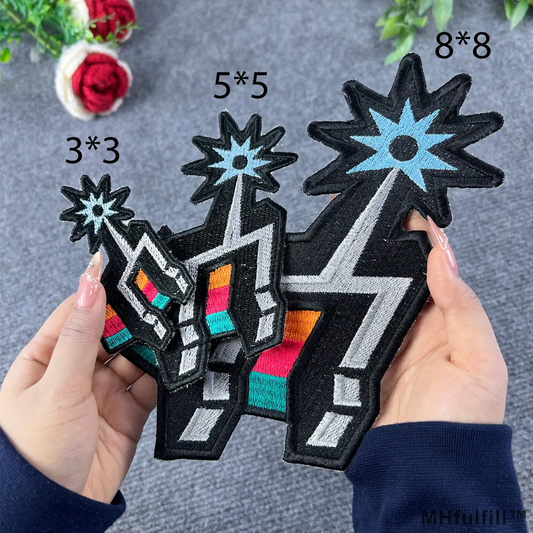 Silver and Black Hoops Spirit Embroidered Patch by MHfulfill featuring a 3x3 inch abstract starburst totem with neon rainbow stripes held by a person.