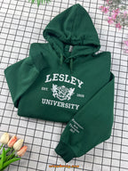 Green hoodie with 'Lesley University' text on a grid background