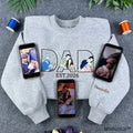 Custom dad photo outline embroidered sweatshirt in grey featuring personalized Father's Day design and phones displaying reference family photos.
