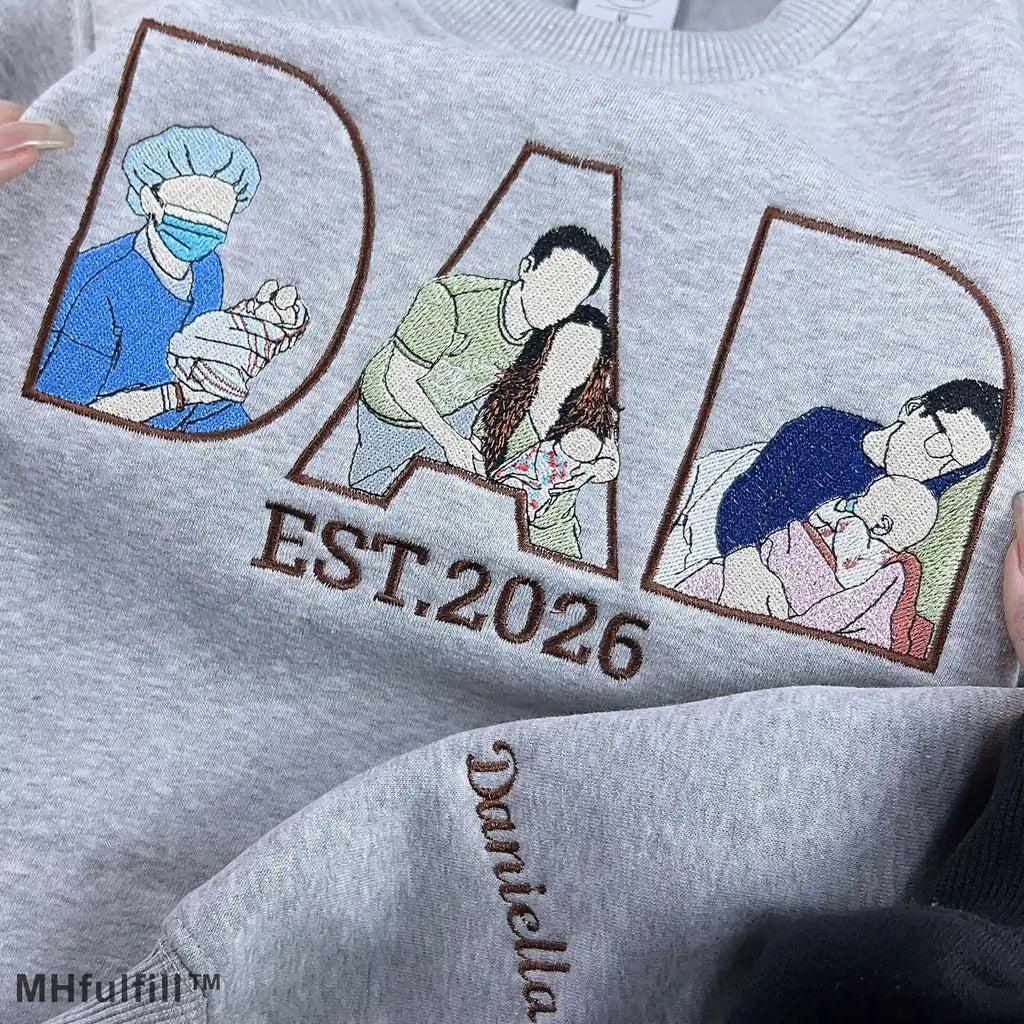 Detailed view of premium satin stitch embroidery showing a father hugging his baby on a personalized custom sweatshirt.