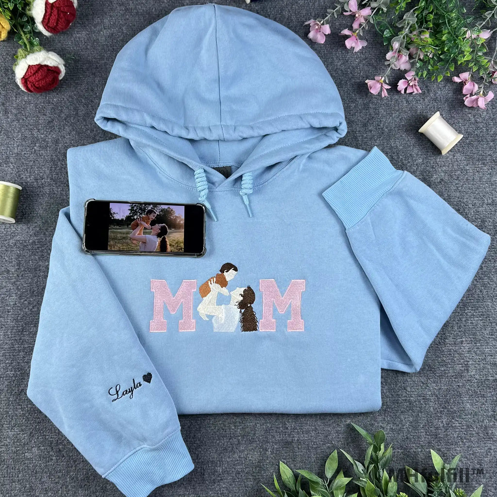 Custom embroidered MOM sweatshirt in light blue featuring a mother and baby portrait design inside the lettering.