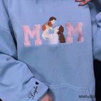 Examples of custom sleeve embroidery displaying children's names on the wrist cuff of a pastel hoodie.