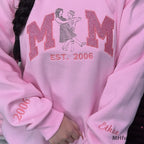 Personalized name Ethan embroidered on the sleeve cuff of a pink custom sweatshirt.
