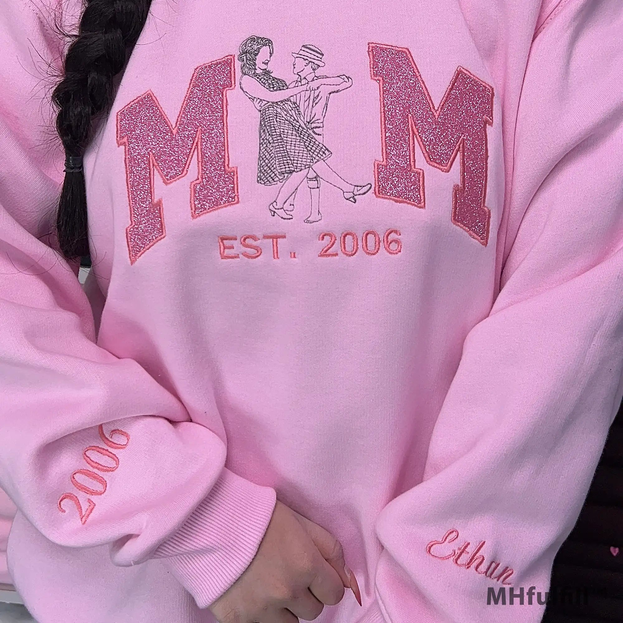 Personalized name Ethan embroidered on the sleeve cuff of a pink custom sweatshirt.
