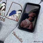 Personalized child name Daniella embroidered on the sleeve cuff of a grey custom dad sweatshirt.