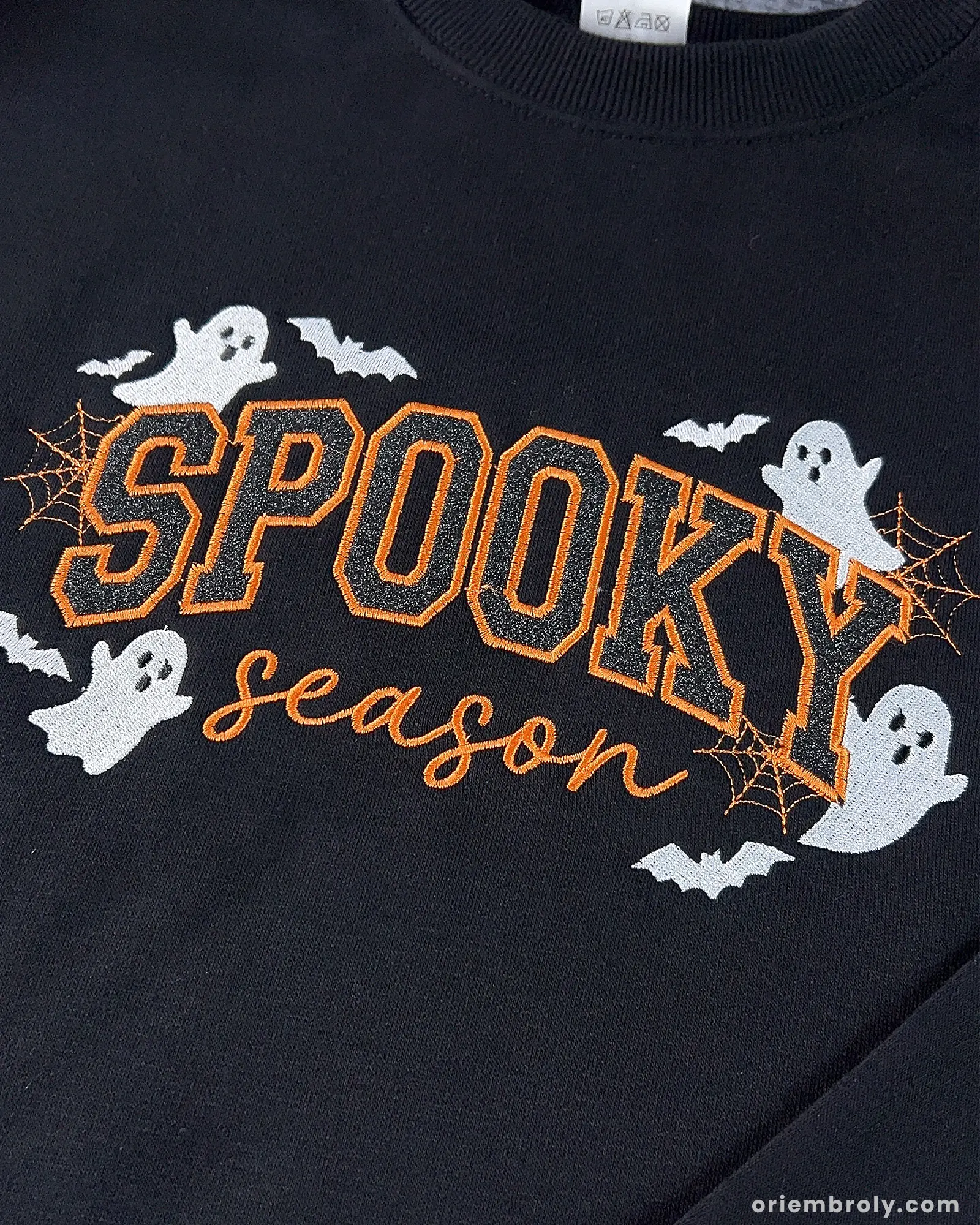 Close-up of embroidered ghosts and bats on Halloween sweatshirt chest