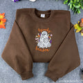 Brown crewneck sweatshirt with embroidered floral lace ghost and wildflowers, front view
