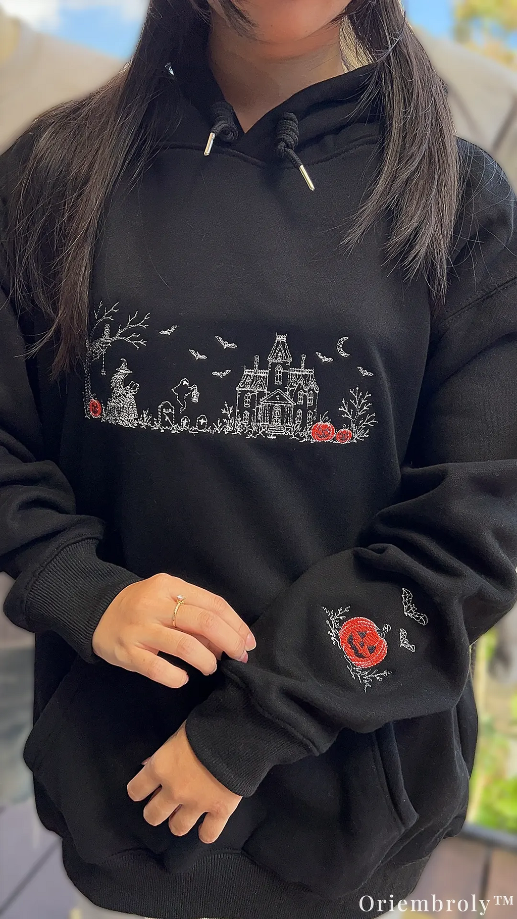 Halloween Village embroidered sweatshirt with witch and haunted house design with model wearing