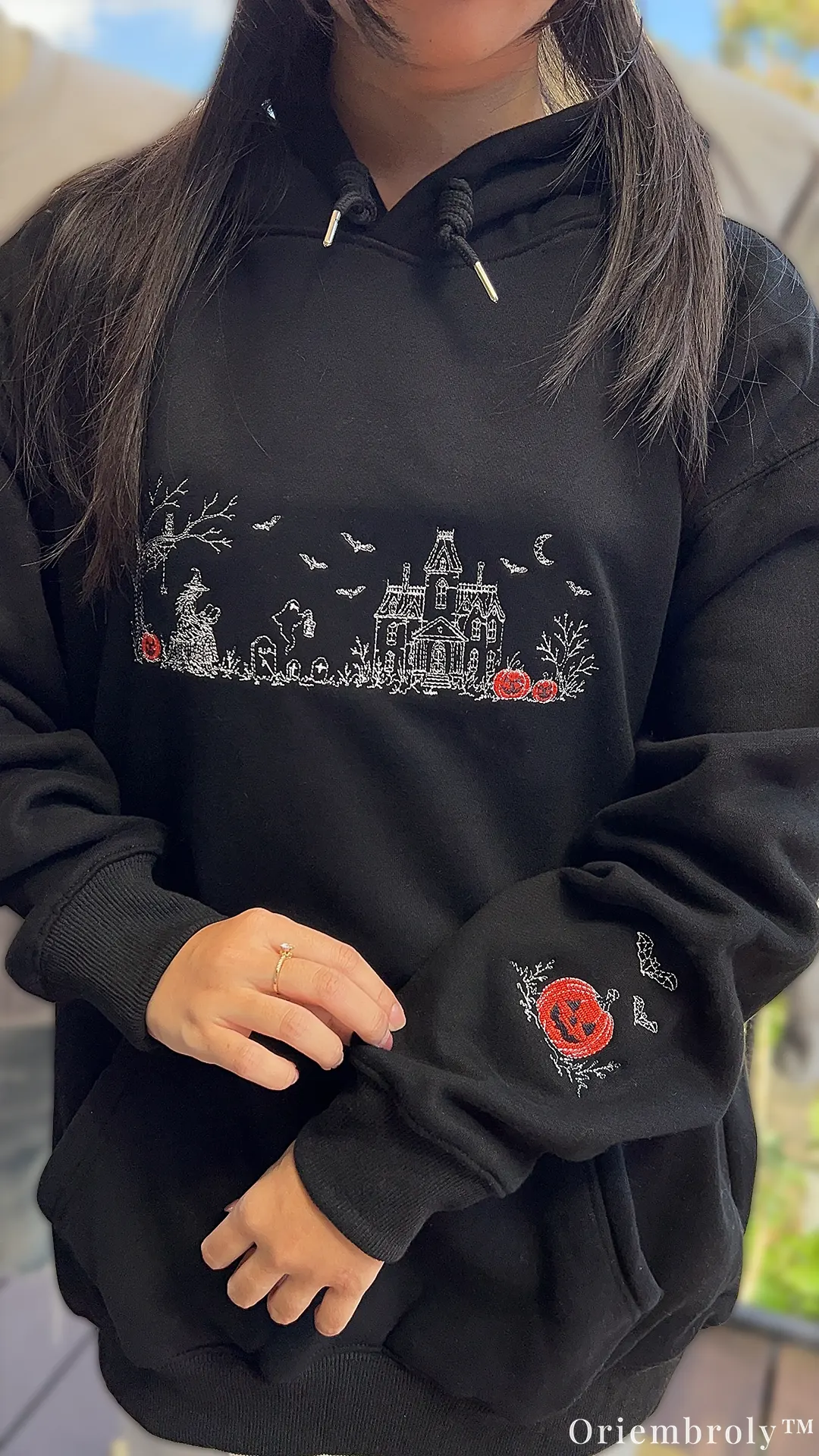 Halloween Village embroidered sweatshirt with witch and haunted house design with model wearing