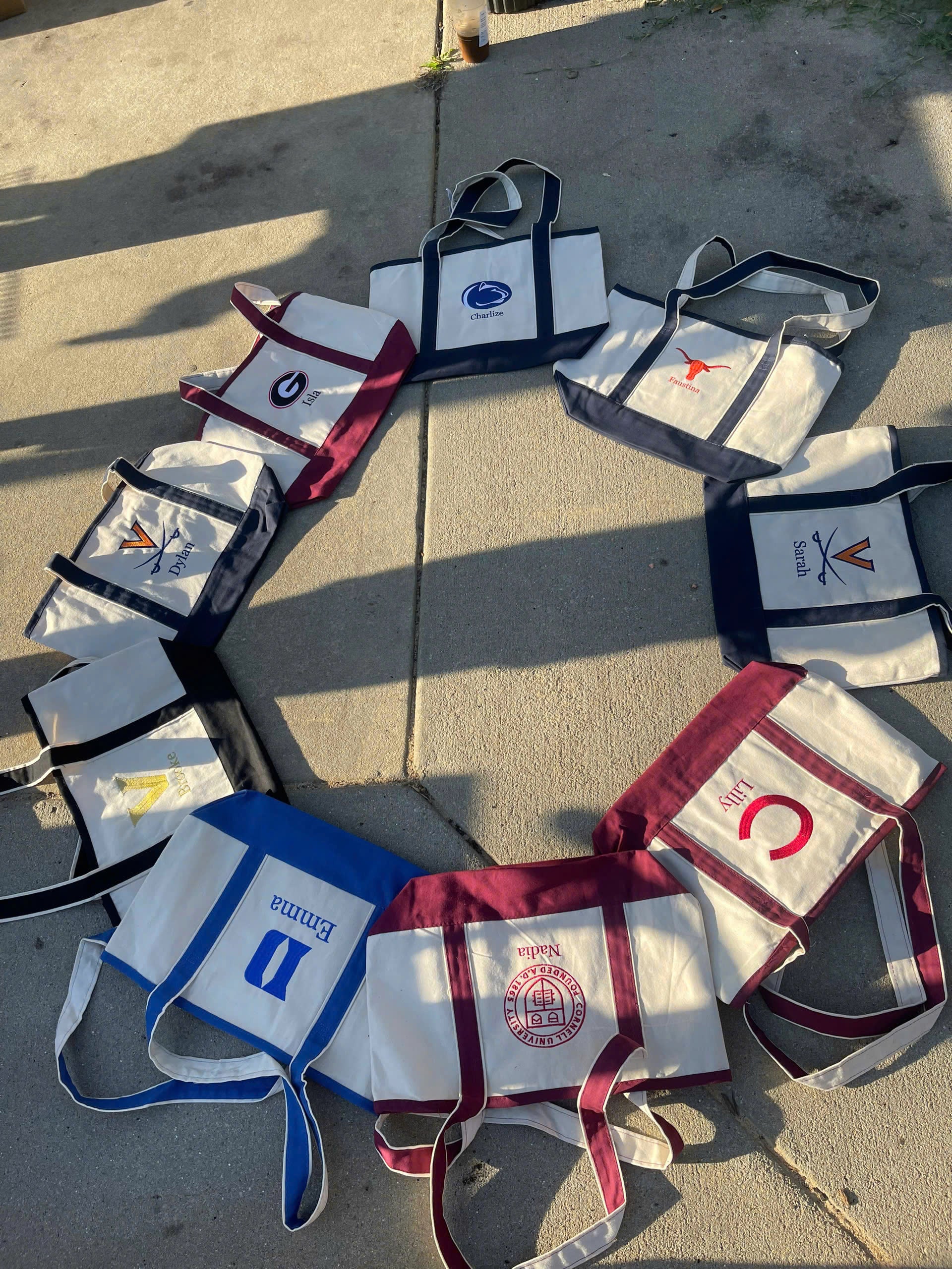 Collection of branded bags arranged in a circular pattern on a concrete surface.