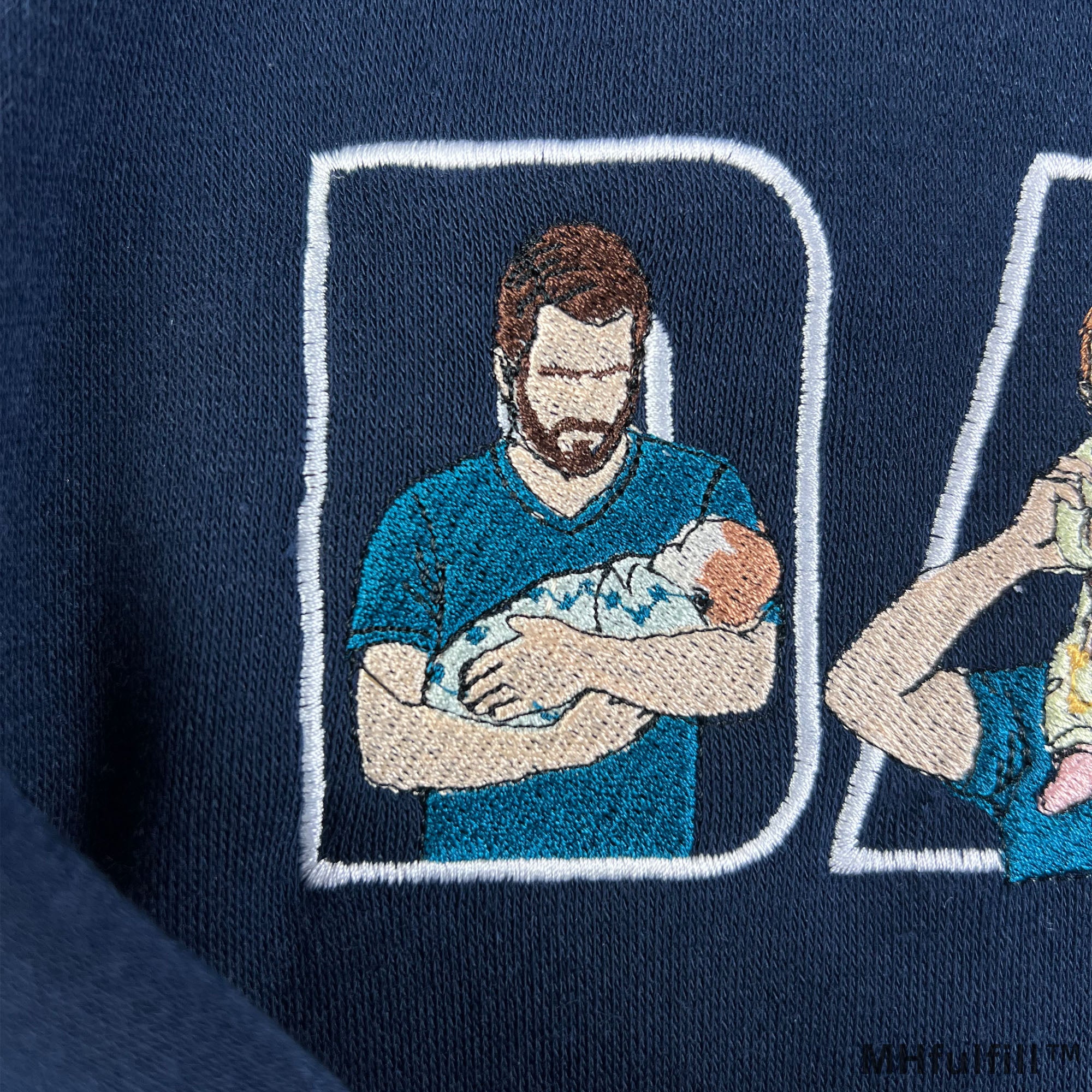 Close-up of high-quality custom embroidery detailing on the MHfulfill Dada sweatshirt.