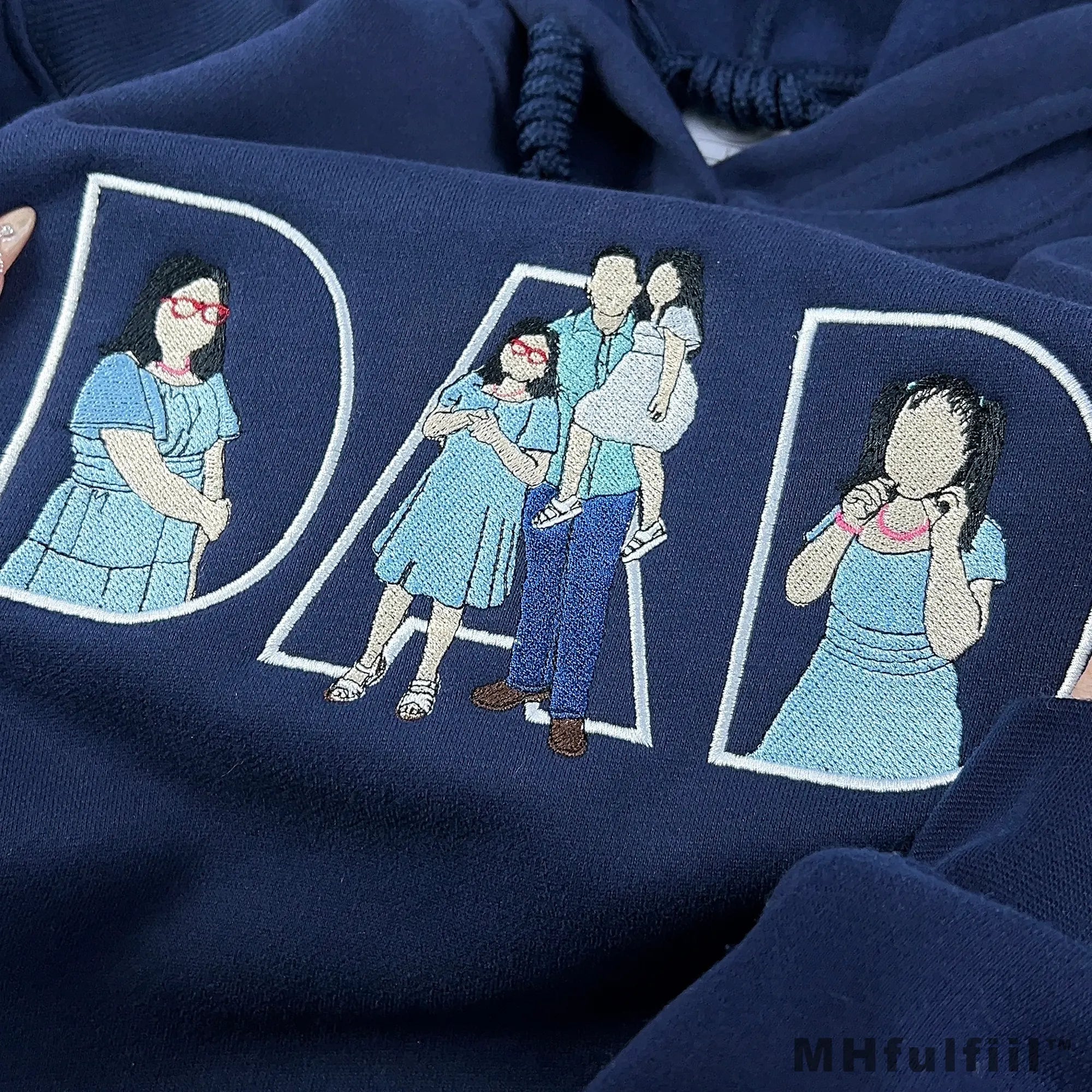 Personalized family photo converted into custom line art embroidery on a dark blue Father's Day hoodie.