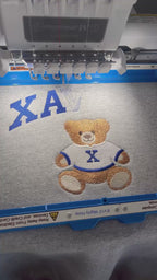Gift box opening revealing a custom embroidered school spirit teddy bear sweatshirt
