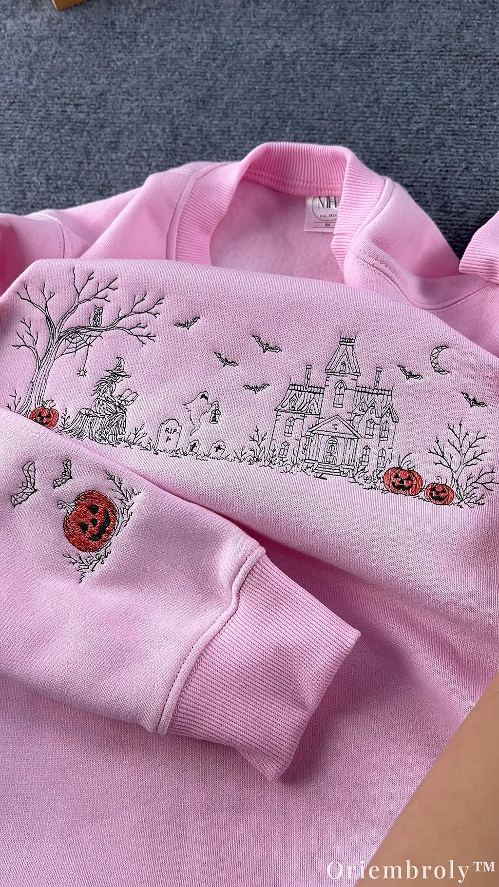 Embroidered jack-o'-lantern detail on sweatshirt sleeve