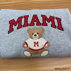 Off-white embroidered college sweatshirt showing a cute teddy bear in a red SHU sweater