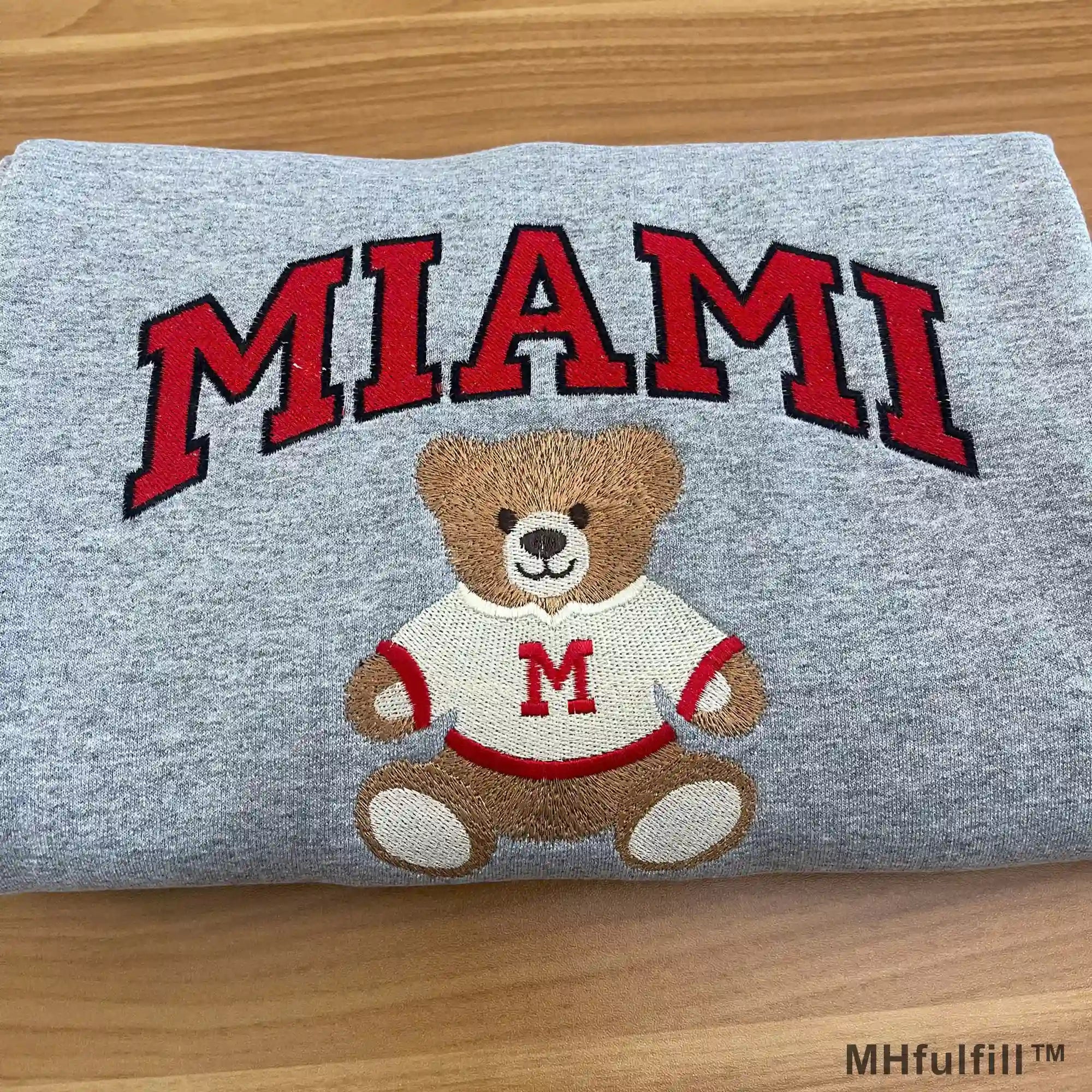 Off-white embroidered college sweatshirt showing a cute teddy bear in a red SHU sweater